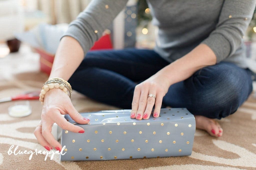 blue and gold wrapping paper for with girl in gray sweater with gold beads